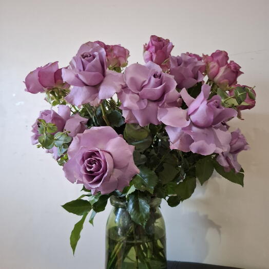 Пышные лиловые и розовые розы в вазе